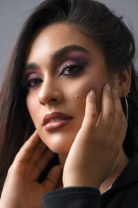 Close-up portrait of a woman with striking makeup and elegant expression.